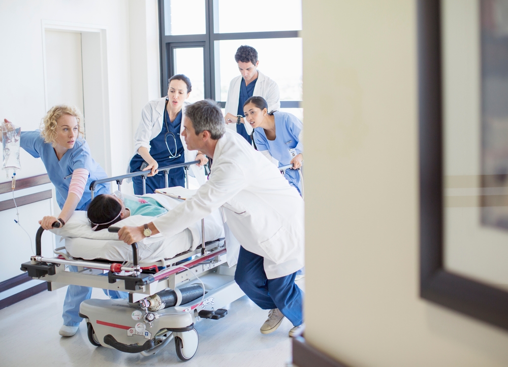 Doctors,And,Nurses,Rushing,Patient,On,Stretcher,Down,Hospital,Corridor Patient being wheeled into ER on a stretcher