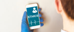 Nurse holds phone screen with the word ethics showing.